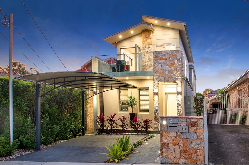 Custom two-storey home with stone feature entry at dusk