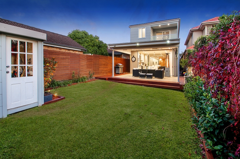 Rear extension opening to deck and garden at dusk